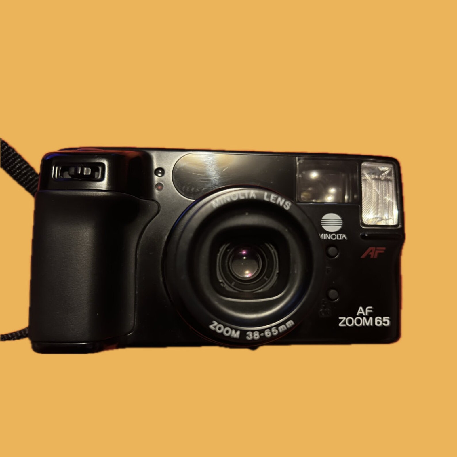Vooraanzicht van de Minolta AF Zoom 65, een compacte 35mm point-and-shoot camera met zoomlens