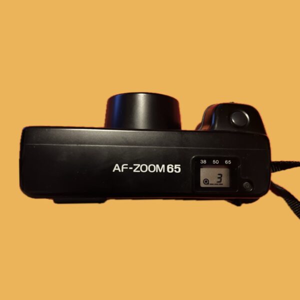 Bovenaanzicht van de Minolta AF Zoom 65 met sluiterknop en flitserinstellingen.