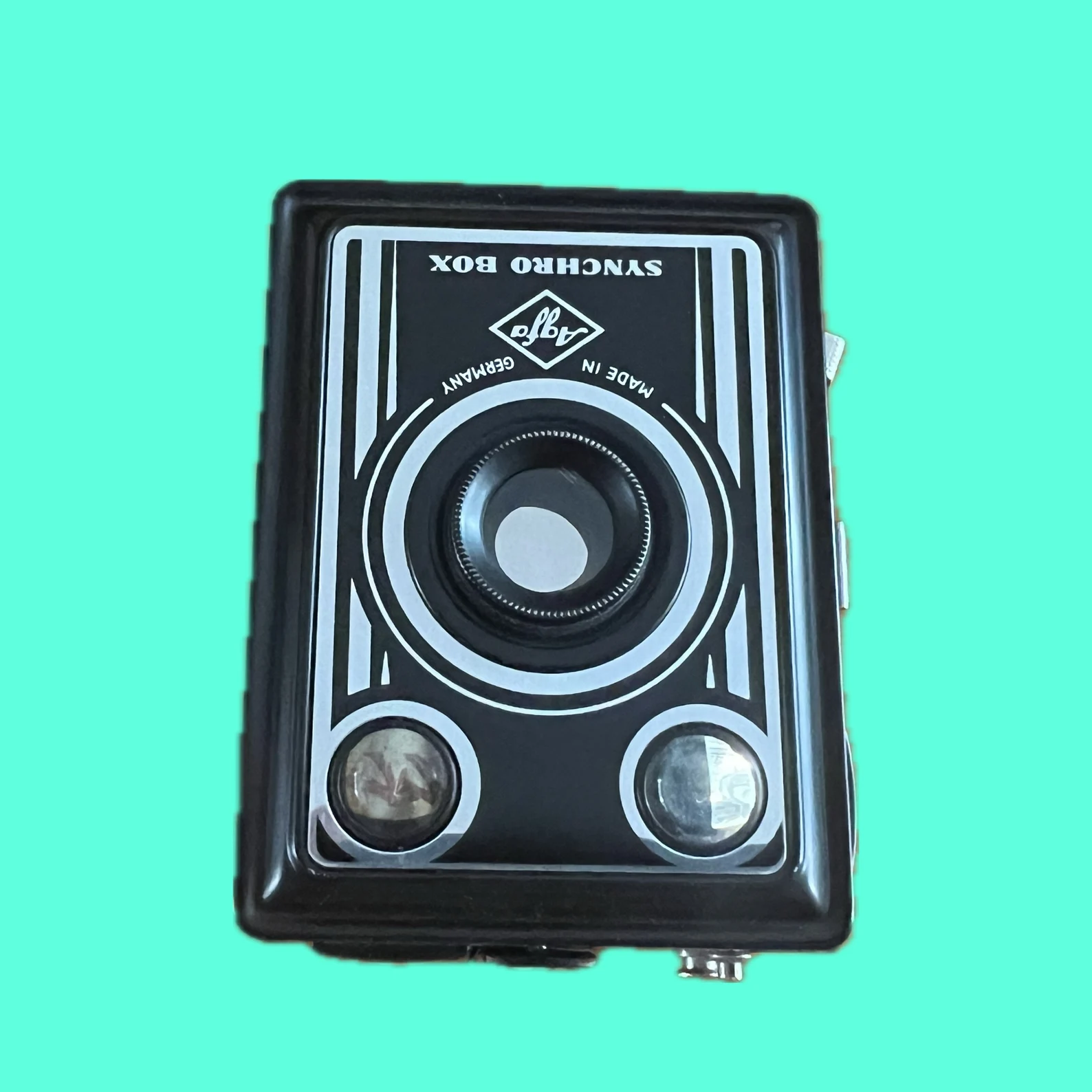 Vooraanzicht van de Agfa Synchro Box, een vintage 120-film boxcamera met metalen behuizing.
